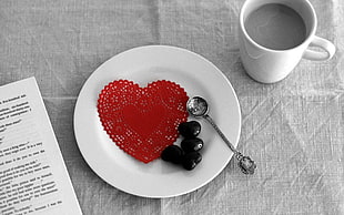 heart-shaped red cloth on plate near mug